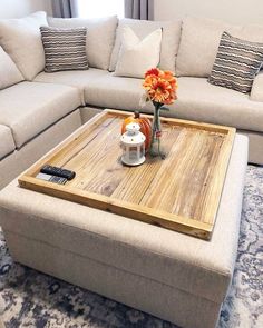 a living room filled with furniture and a large wooden tray on top of the coffee table