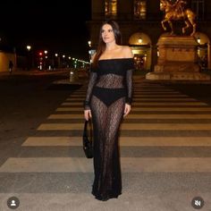 a woman standing in the middle of a cross walk wearing a black lace bodysuit