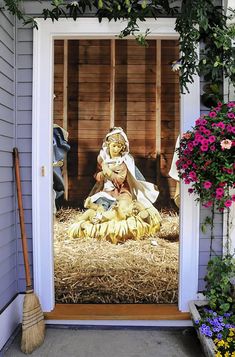 a door with a nativity scene on it and some flowers in the front yard