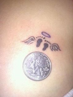 an angel wing tattoo on the side of a woman's stomach, next to a quarter dollar