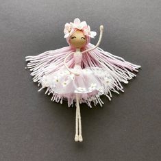 a small doll is dressed in pink and white