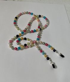 This is a handmade pearl eyeglass chain designed by our Angelic Beader, Miss Sonja.  She used a variety of bright colored 6 mm pearls, which inspired her to name it "The Jelly Bean Eyeglass Chain".  Sonja used Soft Flex beading wire for  extra strength and durability.  The chain is 29" long.  We will send it to you in a gift box with free domestic shipping.  Money from the sale of items in our shop goes to support the ministries and programs of Rocky Cross Baptist Church.  www.rockycross.org Excellent way to keep up with your reading glasses and sunglasses! Hint: Great Mother's Day gift! Multicolor Round Bead Jewelry For Personal Use, Trendy Pearl Glasses Chain As Gift, Trendy Multicolor Glasses Chains As Gift, Adjustable Multicolor Pearl Chain Jewelry, Metal Beaded Glasses Chains For Gifts, Adjustable Multicolor Glasses Chains For Party, Gift Glasses Chains With Colorful Glass Beads, Multicolor Adjustable Glasses Chains For Gift, Multicolor Beaded Glasses Chain As Gift