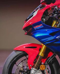 a red and blue motorcycle parked in a garage