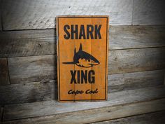 a sign that is on the side of a wooden wall saying shark xing cape club