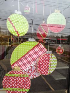 the window is decorated with colorful paper lanterns and other decorative items in red, green, white, and yellow colors