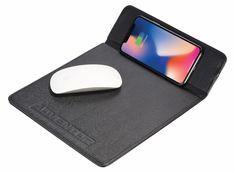 an iphone and mouse sitting on top of a black tabletop with a leather case