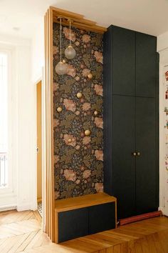 an empty room with two black cabinets and a wallpapered design on the wall