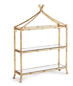 a gold bamboo shelf with glass shelves on it and a metal hanger over the top