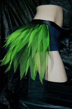 a mannequin wearing a green and black corset with leaves on it