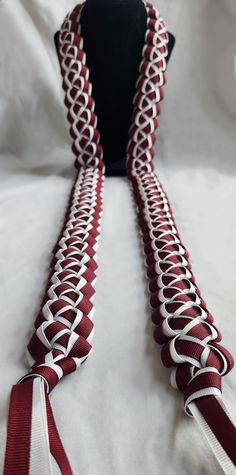 a red and white neck tie on a black stand