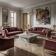 a living room filled with lots of furniture next to a painting on the wall above a coffee table