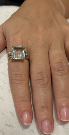 Appraised at $5,150.00, This Aquamarine Ring consists of 1 rectangular aquamarine measuring 13.90 x 11.92 x 6.87 mm (7.8 ct). It also has 2 cubic Zirconia one on each side of the aquamarine. The ring weights 6.5 grs of 14kYG. Luxury Rectangular Diamond Ring With Accent Stones, Elegant Topaz Rings With Rectangular Stone, Luxury Rectangular Topaz Anniversary Ring, Classic Radiant Cut Topaz Ring With Accent Stones, Elegant Rectangular Topaz Ring For Formal Occasions, Luxury Gia Certified Aquamarine Ring, Elegant Formal Rectangular Topaz Ring, Formal Aquamarine Ring With Diamond Accents, Luxury Topaz Ring With Rectangular Stone For Gift