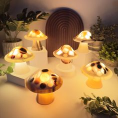 a group of mushrooms sitting on top of a table next to plants and potted plants