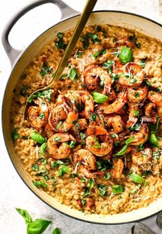 a skillet filled with shrimp and rice, garnished with parsley on top