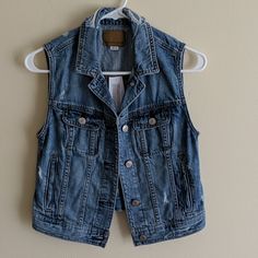 Denim Vest Spring Casual Medium Wash Denim Vest, Blue Casual Relaxed Fit Denim Vest, Trendy Blue Denim Vest For Everyday, Casual Medium Wash Denim Vest For Spring, Casual Relaxed Fit Dark Wash Denim Vest, Casual Distressed Cotton Denim Vest, Casual Distressed Denim Vest For Spring, Casual Distressed Denim Blue Vest, Casual Dark Wash Denim Vest