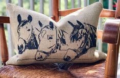 a pillow with horses on it sitting on a chair