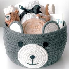 a crocheted basket with stuffed animals and personal items in it on a table