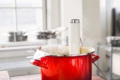 a red pot sitting on top of a wooden table