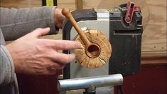 a person is working on a machine with wood and metal parts in the foreground