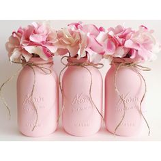 three pink mason jars with flowers in them