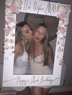 two women are posing in front of a white frame with flowers on it and the words happy 18th birthday