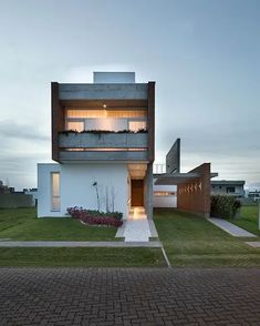 the modern house is located in an area with grass and brick paversed walkways