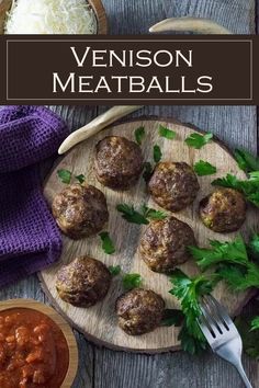 meatballs with sauce and parsley on a wooden plate next to a purple towel