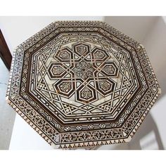 an intricately designed wooden table top in the shape of a flower ornament