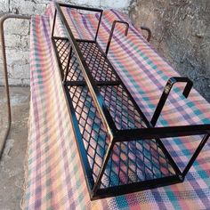 a metal bench sitting on top of a checkered blanket