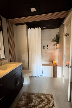 a bathroom with a sink, toilet and bathtub next to a shower curtain that is open