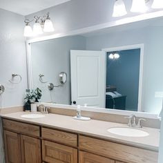 a bathroom with two sinks and a large mirror