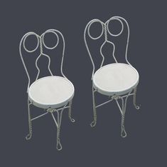 two white chairs sitting next to each other on top of a black surface with circles around them