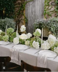 the table is set with white flowers and place settings for guests to sit down at