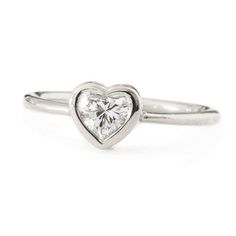 a heart shaped ring with a diamond in the middle and a single stone on top