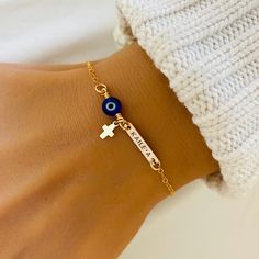 Dainty Evil Eye Bracelet, Baby First Bracelet, Christening Jewelry, Cross Bracelet, Protection Jewelry, Amulet Bracelet, Blue Evil Eye ❤ Available in silver, gold and rose gold. ❤ Specification . All components are 925 Sterling Silver/ 14K Gold Filled/ 14K Rose Gold Filled . Evil Eye bead size is 6mm . Bar size is 16 x 3.2mm . Length includes pearl, jump ring and clasp . Comes in our signature pouch ready for gift giving ❤ Religious Bracelets: http://etsy.me/2s2rTLz ❤ Religious Necklaces: http://etsy.me/2rITweG ❤ All collections from StampedEve: https://www.etsy.com/au/shop/StampedEve?ref=l2-shopheader-name IMPORTANT: Usually jewellery in the pictures looks bigger than in reality. Please consider all given dimension and compare them to the ruler before ordering. ❤ About My Jewellery Each p Personalized Blue Bracelets, Blue Personalized Spiritual Bracelets, Personalized Blue Spiritual Bracelets, Spiritual Personalized Blue Bracelets, Blue Name Bracelet For Mother's Day Gift, Mother's Day Blue Name Bracelet Gift, Blue Friendship Bracelets With Charms, Blue Rosary Bracelet Gift, Religious Necklaces