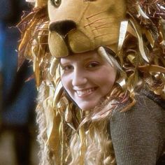 a woman wearing a lion costume with long blonde hair and big eyes smiling at the camera