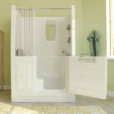 a bath tub sitting next to a wooden cabinet in a bathroom on top of a rug