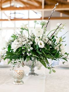 White wedding, wedding greenery, winter wedding, spring wedding, compote bowl centerpiece, flower centerpiece, wedding flowers, playa blanca roses, ranunculus, ginestra, spray allium, clematis pods, freesia, hellebore, lisianthus, delphinium, pussy willow, greenery, Pear Tree Estate, Champaign, Illinois wedding, central Illinois wedding, midwest wedding, J.Blu Design Wedding and Event Florist, Peoria wedding, Italian ruscus, silver accent, silver votive candles, round tablescape, candles, votive Compote Bowl Centerpiece, Greenery Winter Wedding, Silver Votive Candles, Greenery Runner, Champaign Illinois, Greenery Centerpiece, Silver Centerpiece, Bowl Centerpiece, Wedding Silver