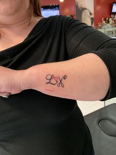 a woman with a love tattoo on her arm