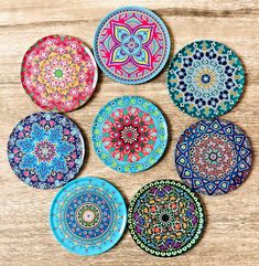 six colorful plates sitting on top of a wooden table