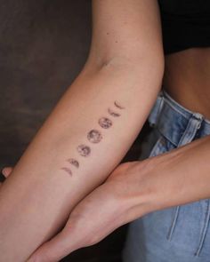 two women with tattoos on their arms holding each other's hands and the word love is written in cursive letters