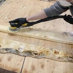 a man sanding wood on top of a wooden floor