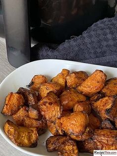 a white plate topped with fried food next to a toaster oven