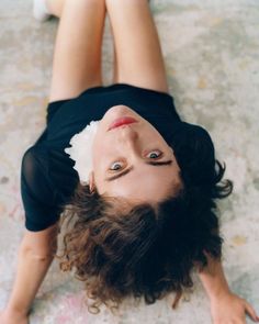 a woman laying on the ground with her eyes open