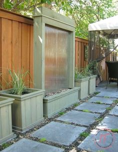 an outdoor water fountain surrounded by two planters