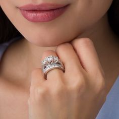 a close up of a person wearing a ring with two diamonds on the middle of it