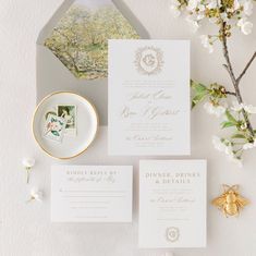 the wedding stationery is laid out next to some flowers