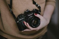 a woman holding a camera in her hands