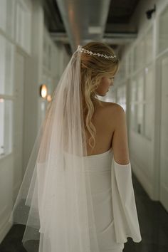 a woman in a white dress is wearing a veil