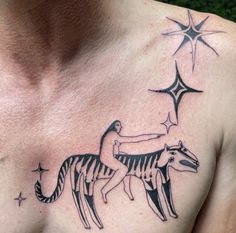 a man with a tattoo on his chest is riding a horse and the stars are in the sky